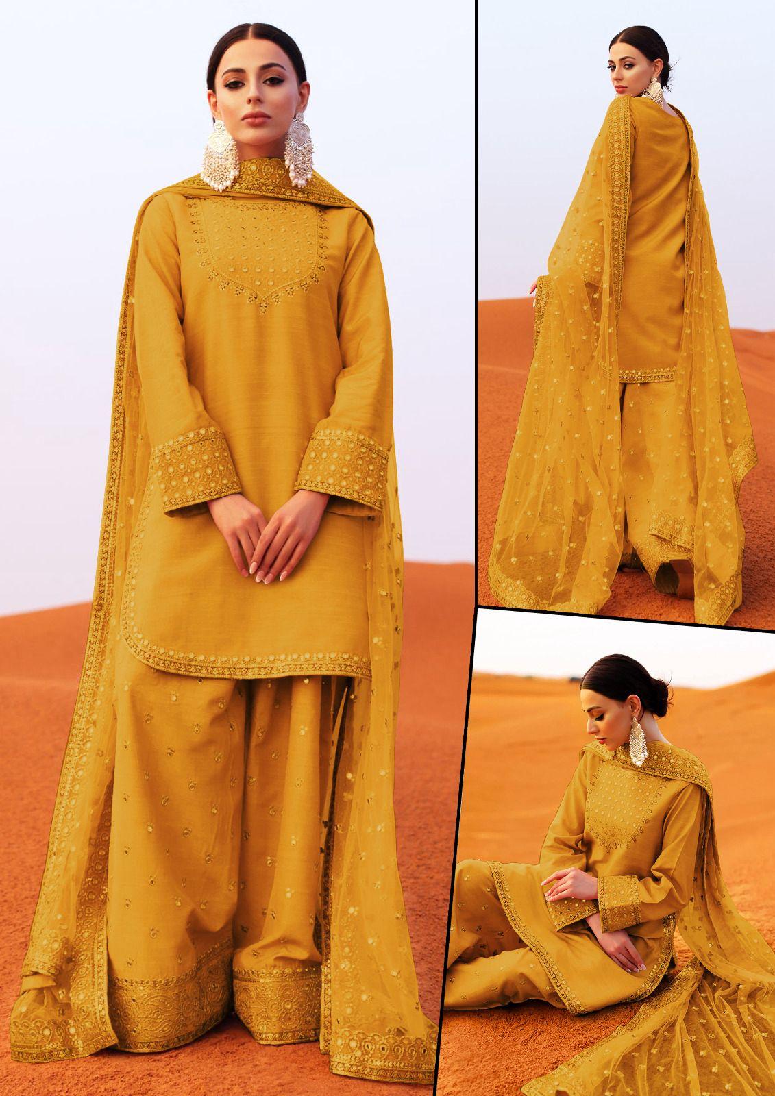 Mustard yellow traditional outfit with intricate patterns on a desert background