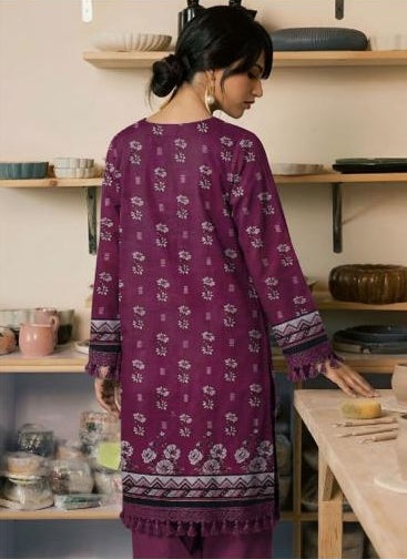 Woman wearing a purple embroidered shirt and pants in a kitchen setting, with 'Ripple Collection' branding.