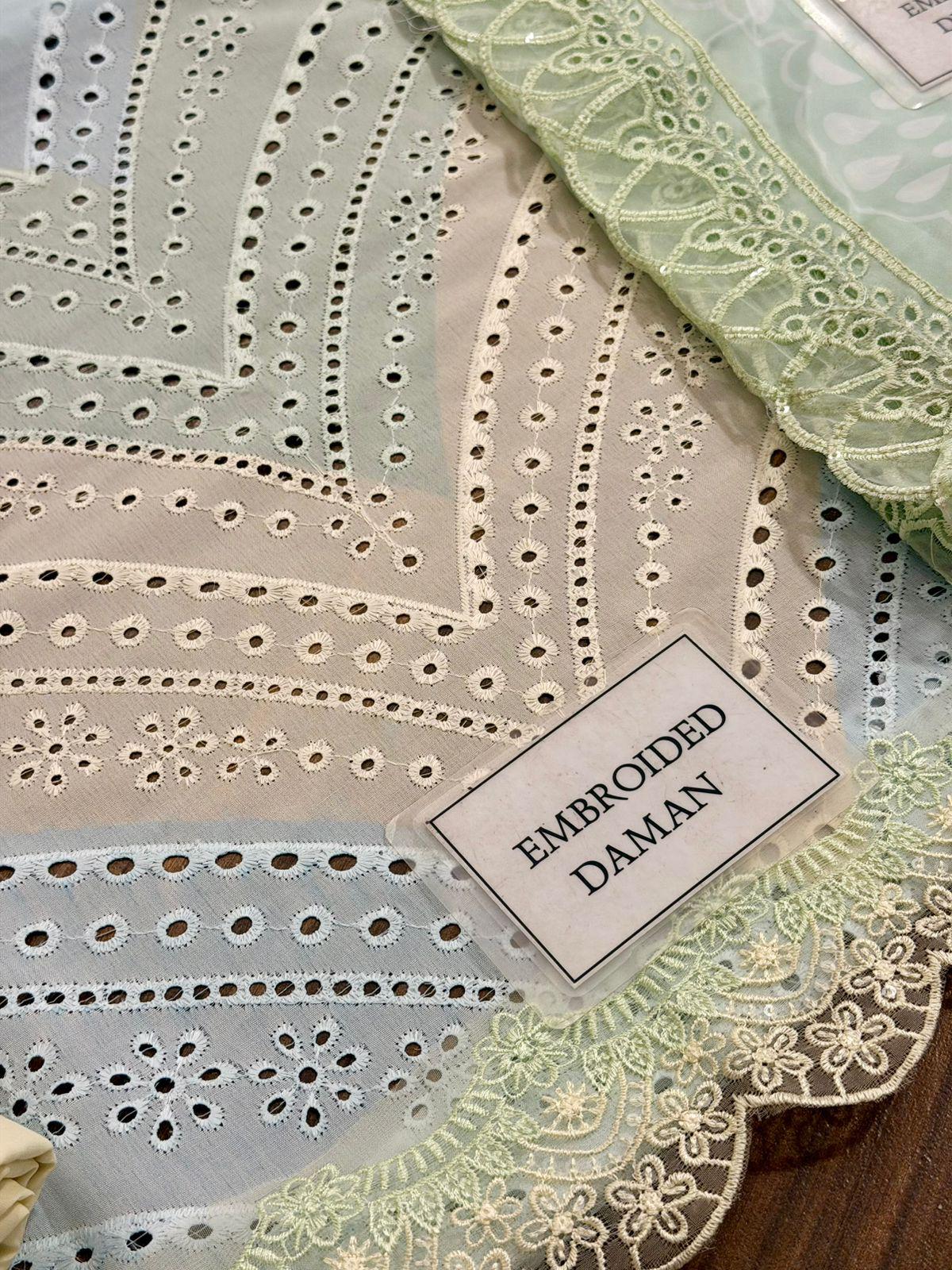 Embroidered fabric with a label indicating 'Embroidered Daman' on a wooden surface.