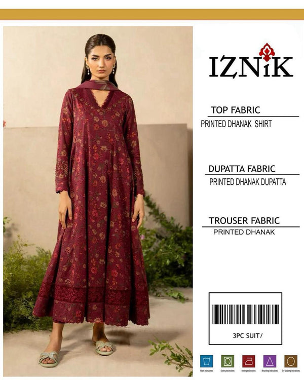 Woman wearing a maroon printed outfit with Iznik branding on a beige background