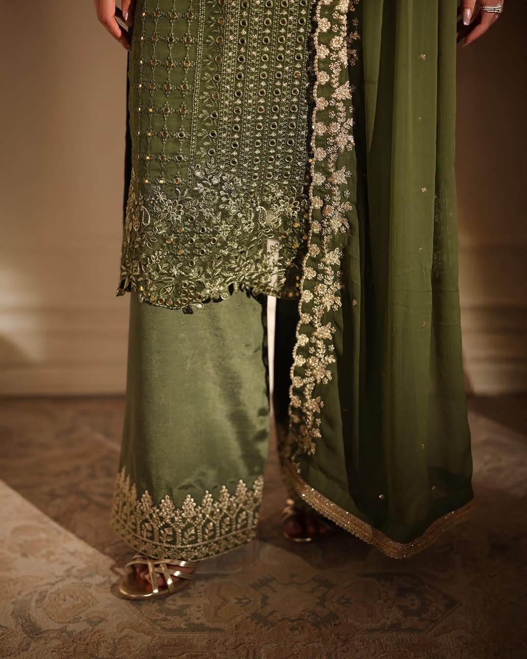 Green embroidered traditional outfit with a plain background