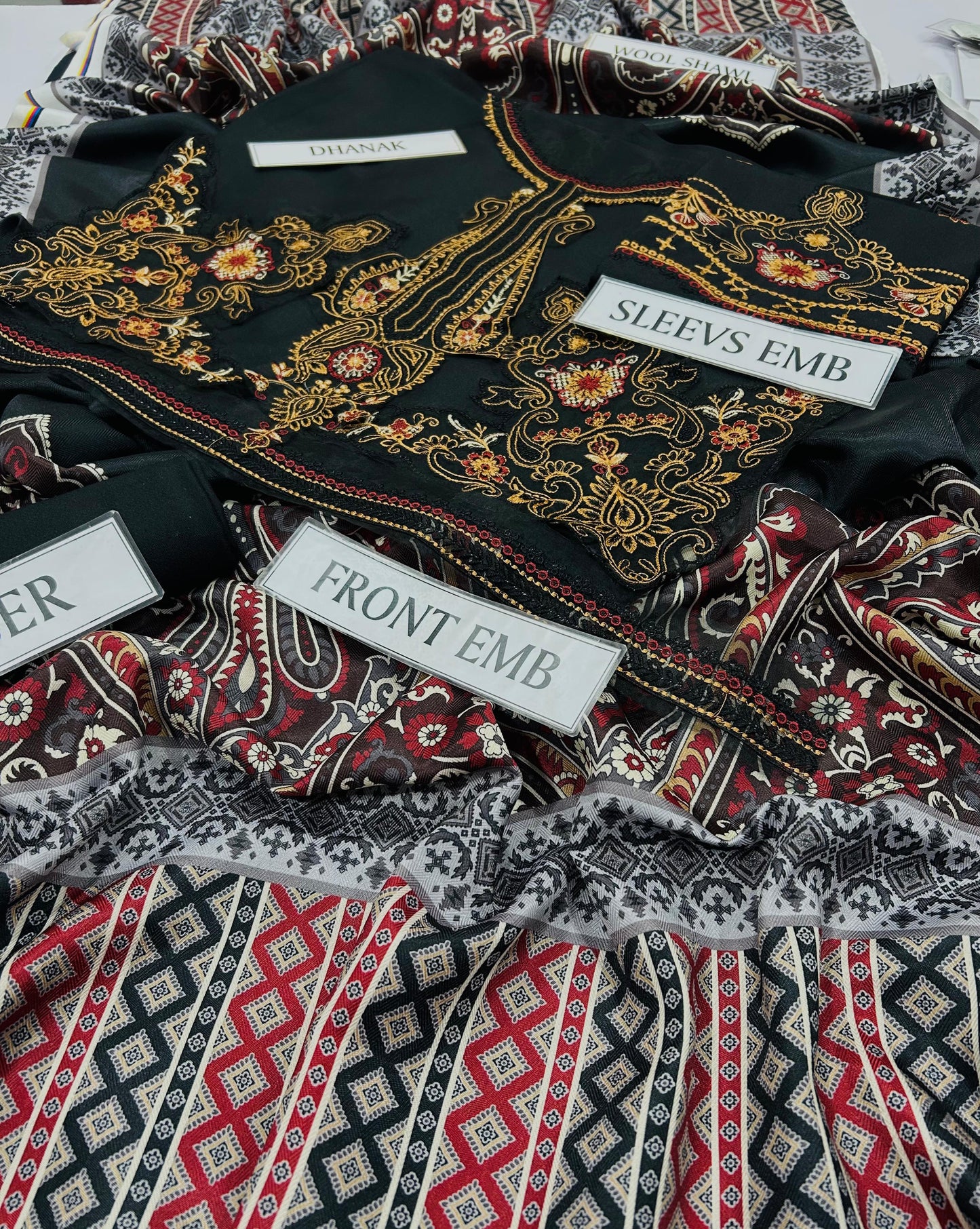 Embroidered fabric with labels indicating 'Front Emb' and 'Sleeve Emb'.