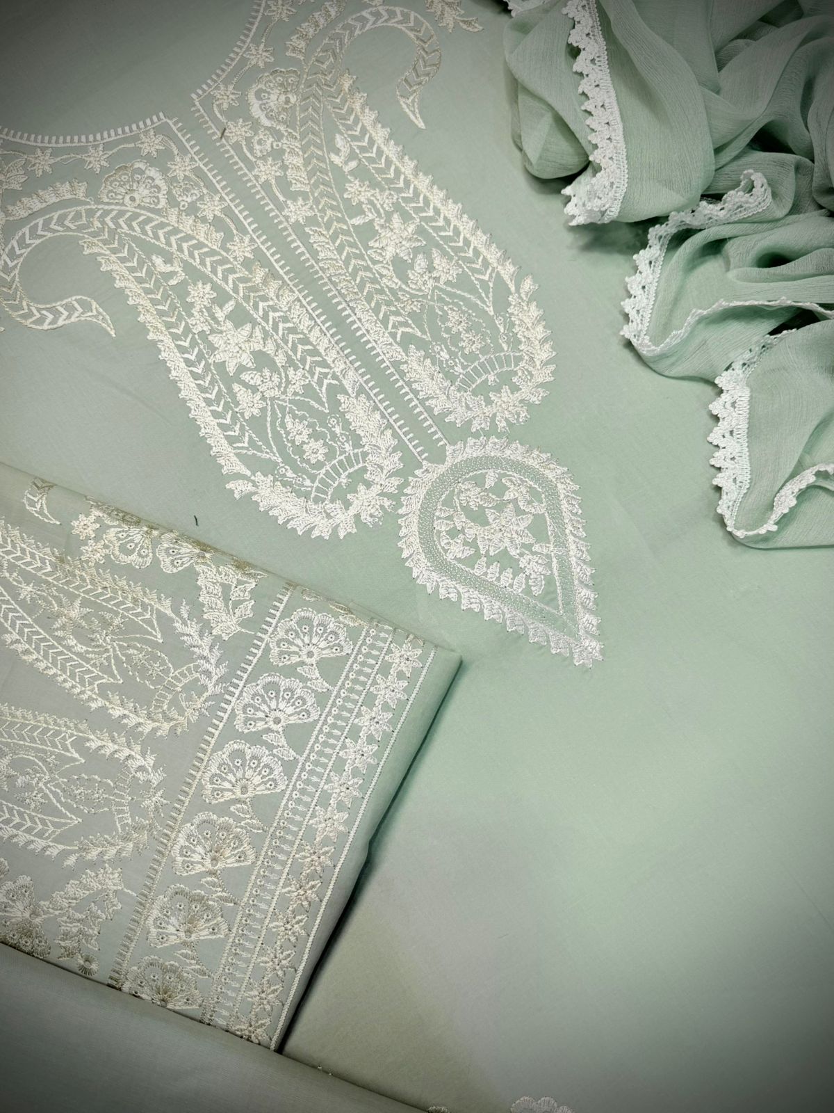 Light green fabric with white lace patterns