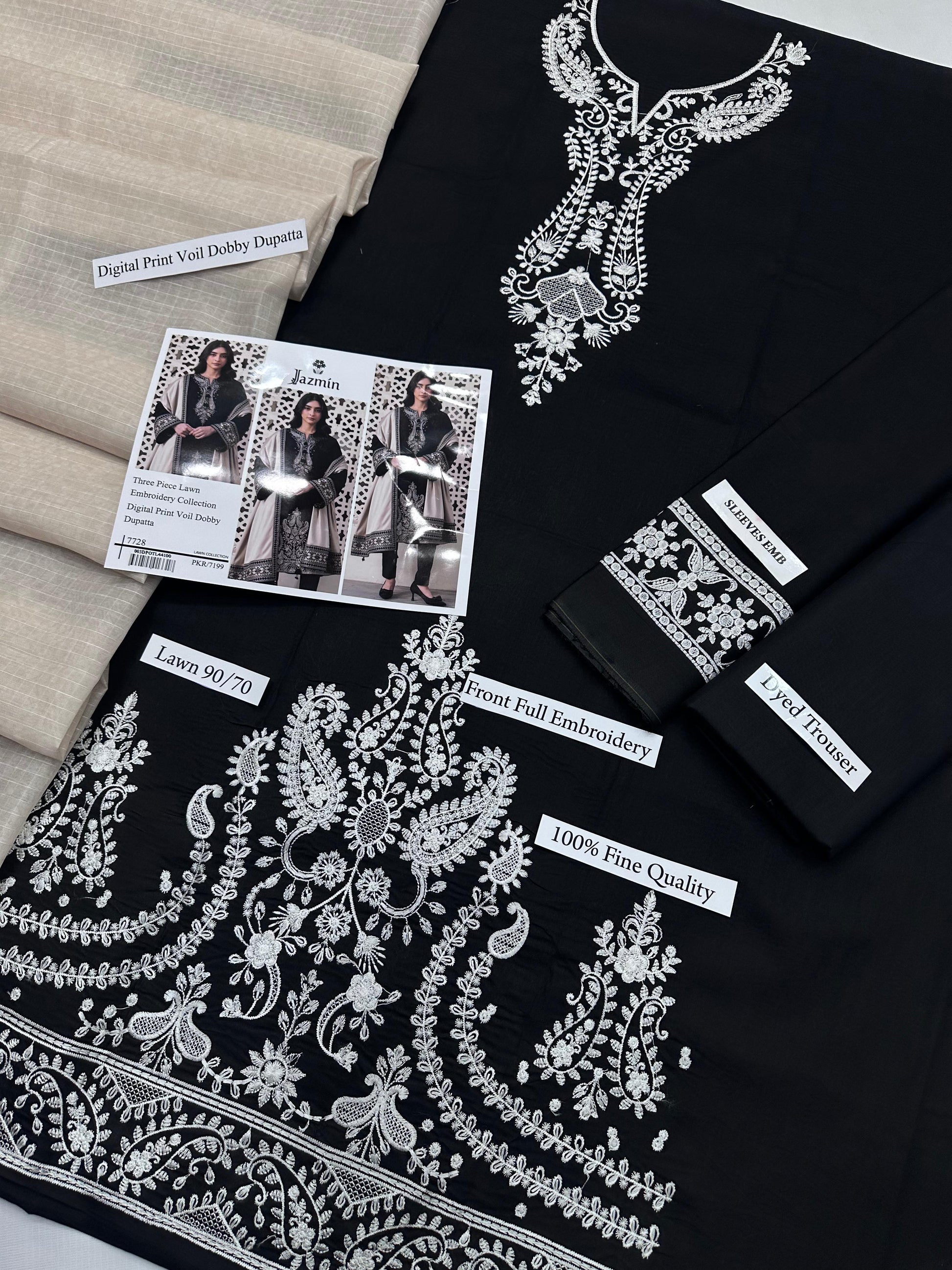 Black fabric with white embroidery and product tags on a neutral background