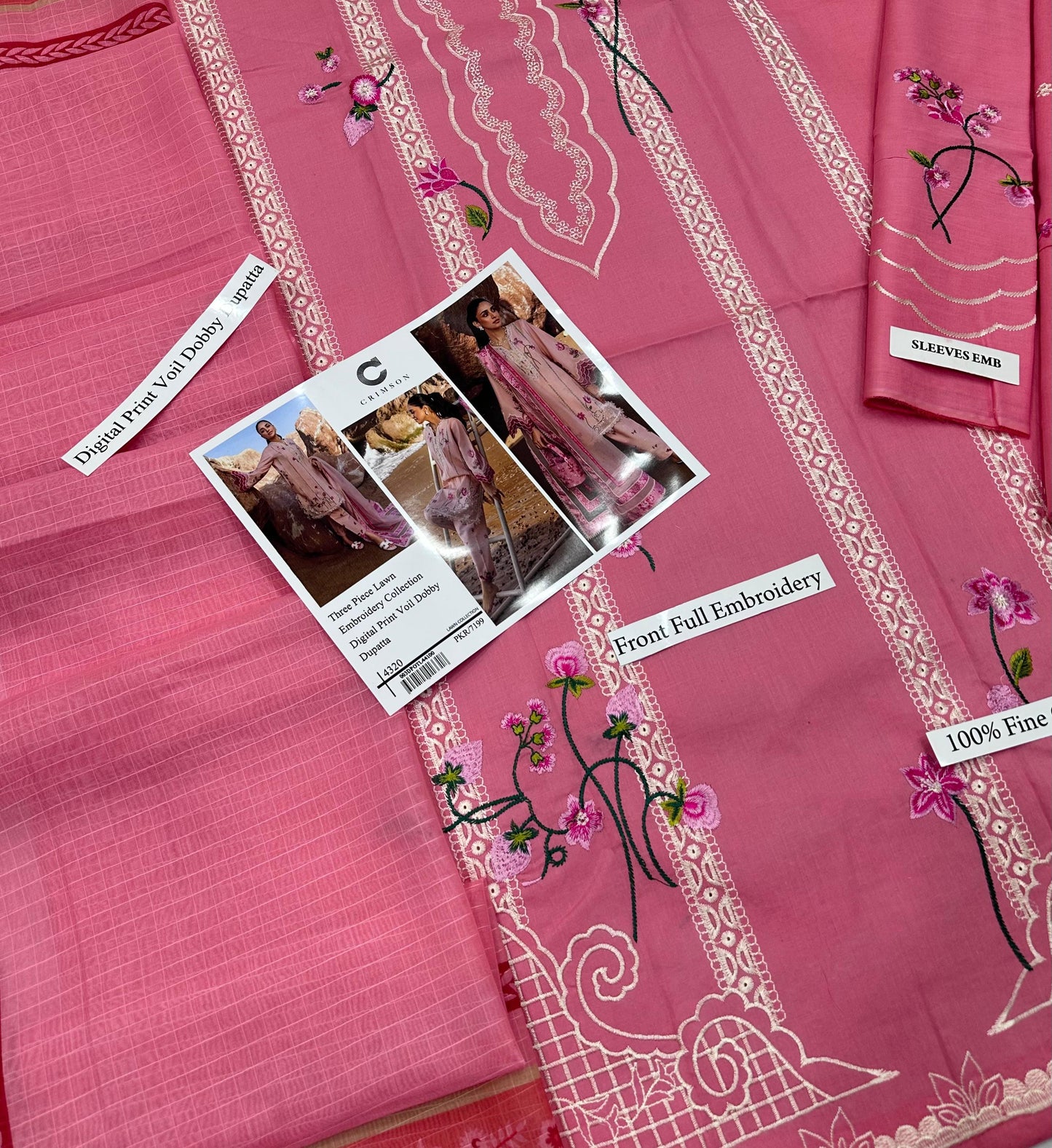 Pink fabric with embroidery and a label on a pink background