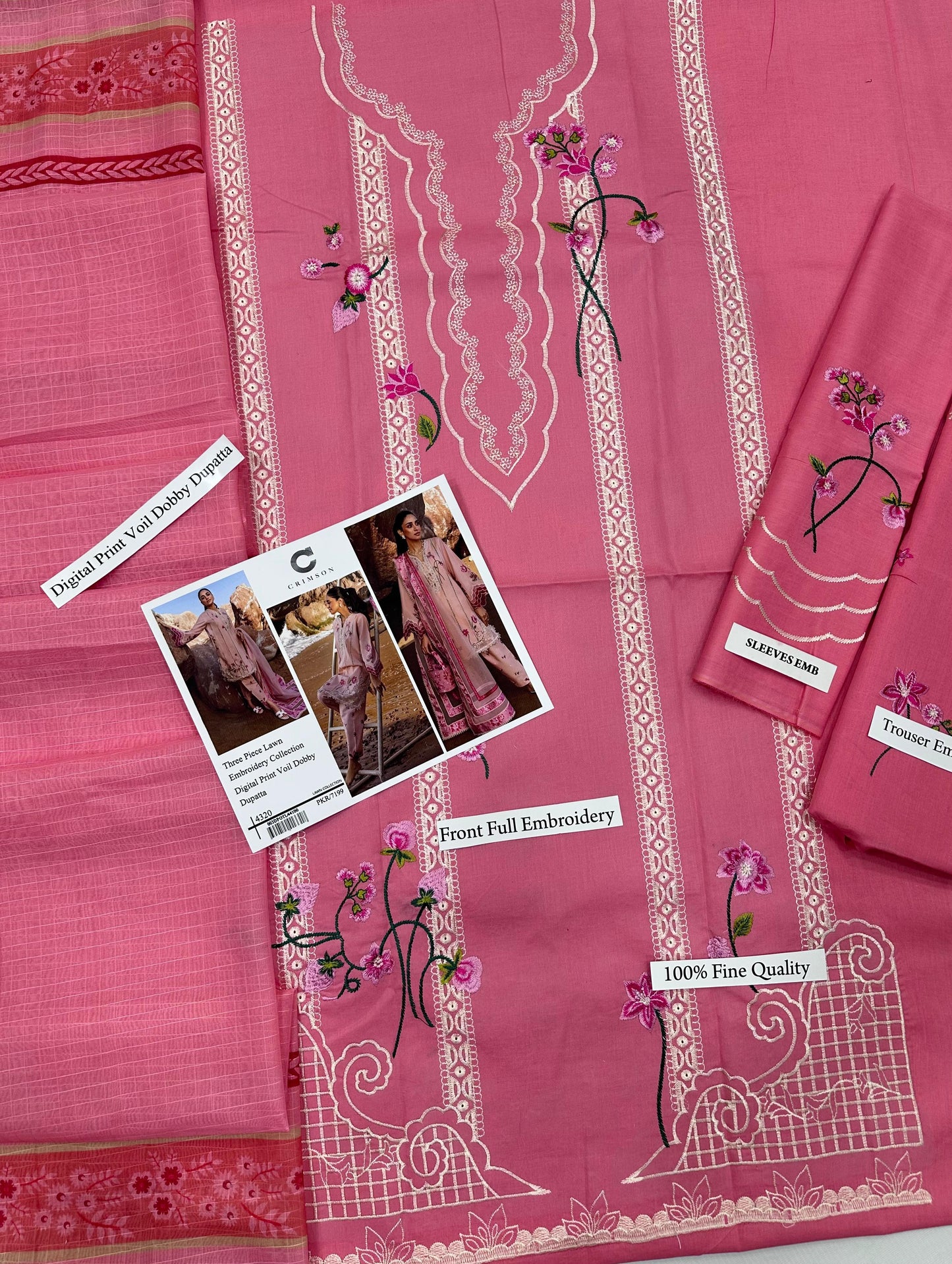 Pink fabric with white embroidery and floral patterns, displayed on a flat surface.