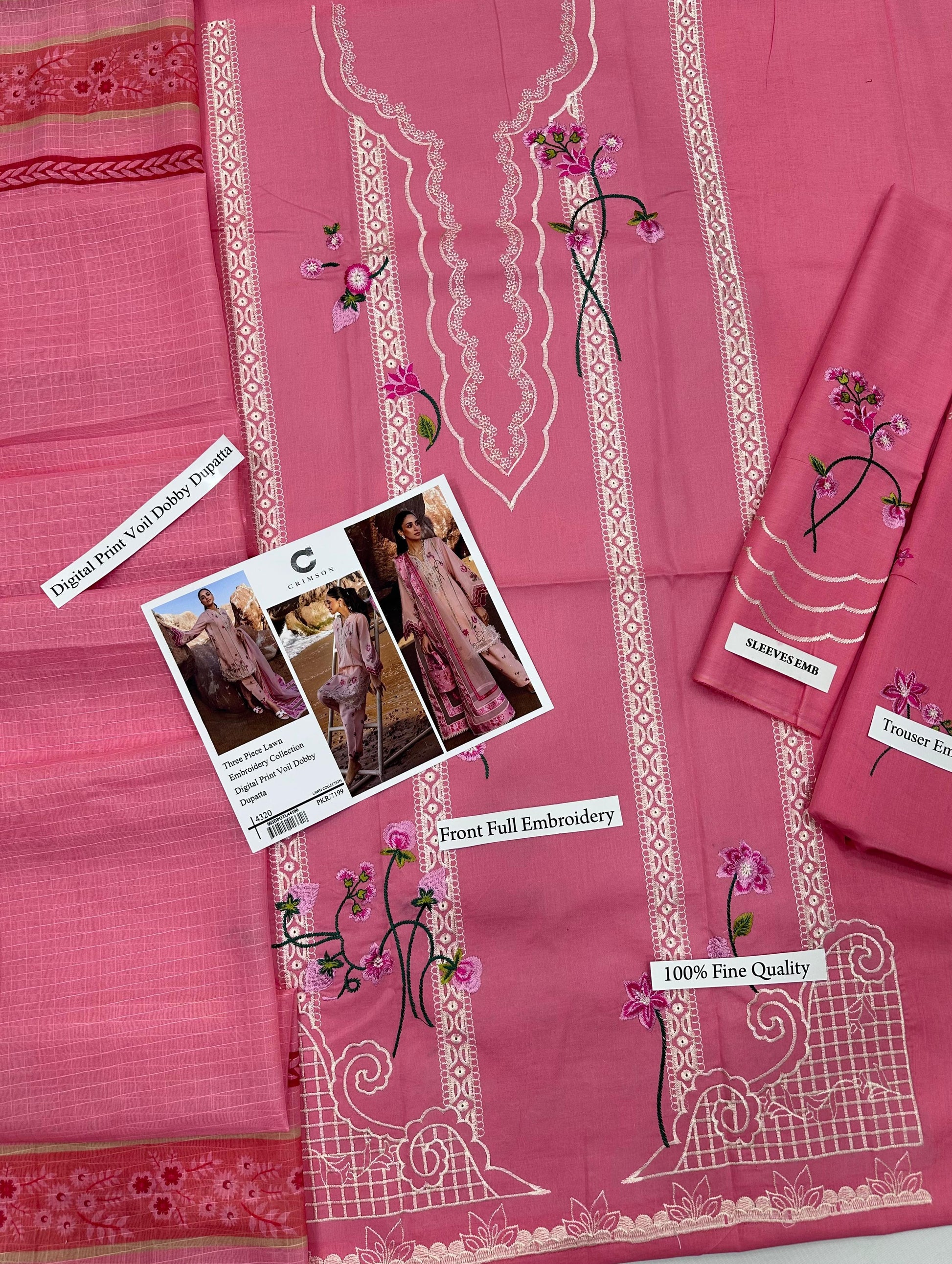 Pink fabric with white embroidery and floral patterns, displayed on a flat surface.