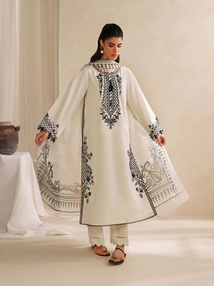 Woman wearing a white embroidered traditional outfit in a minimalistic setting
