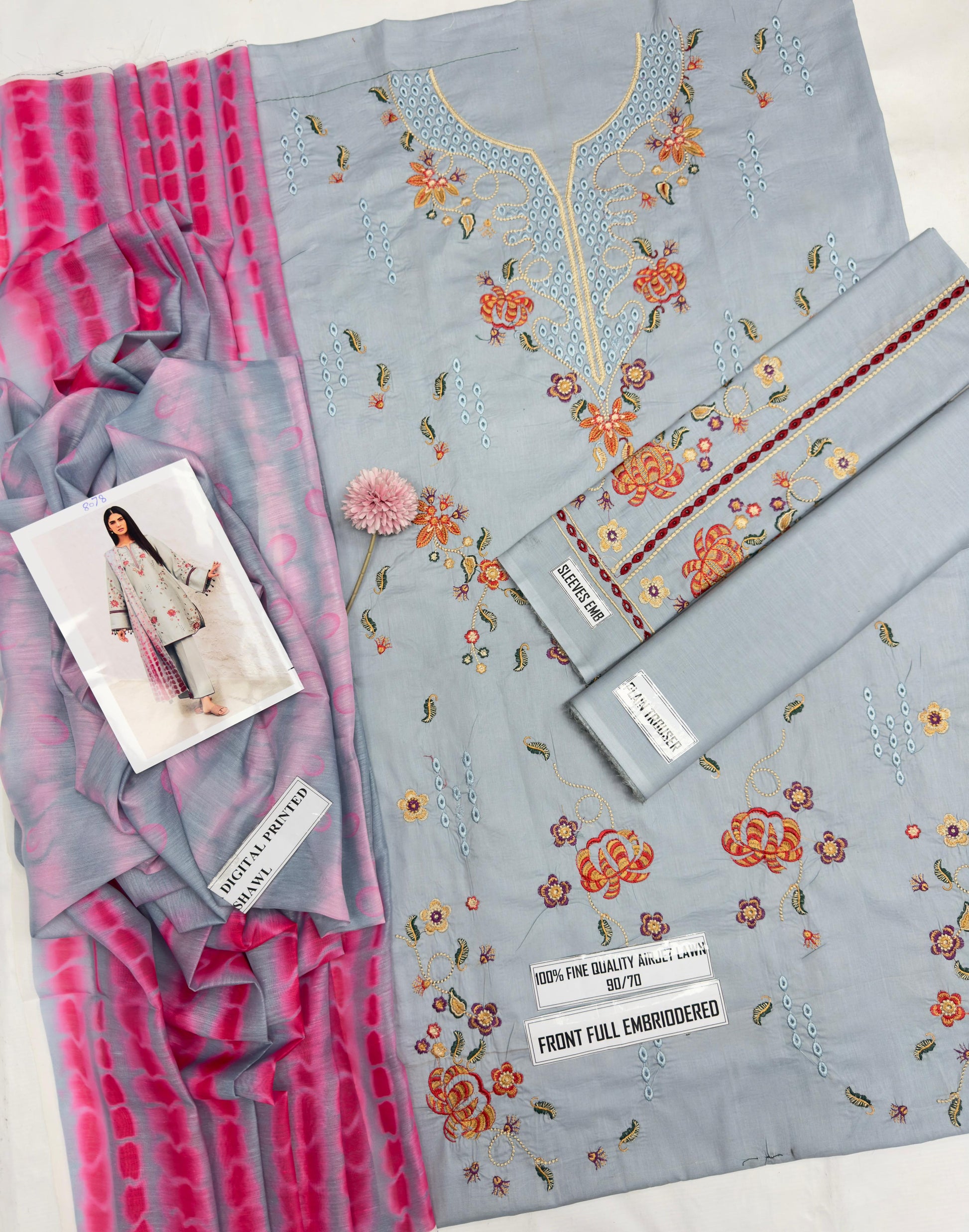 Gray fabric with floral embroidery and pink striped fabric on a white background