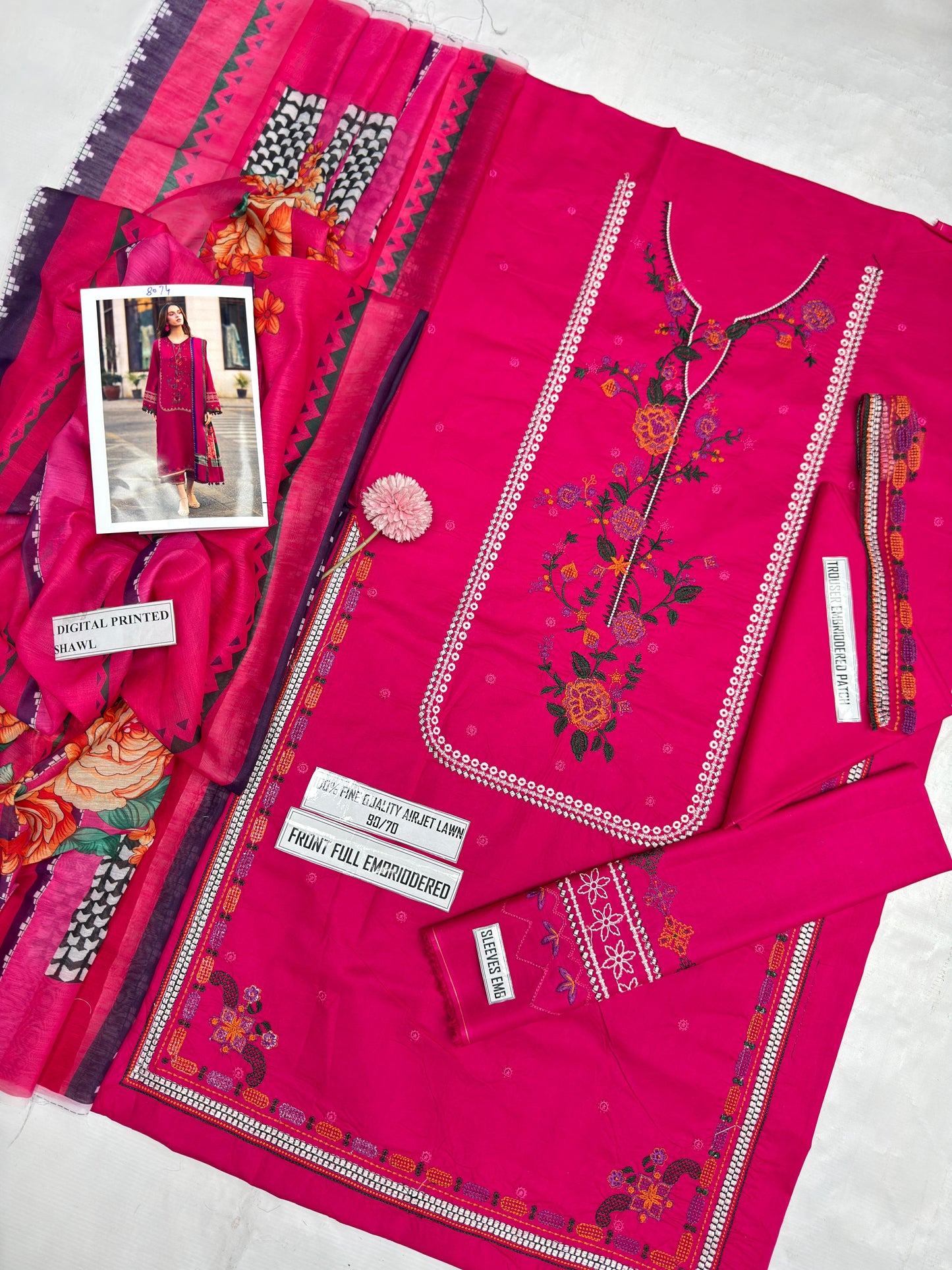 Pink embroidered fabric with floral patterns on a white background