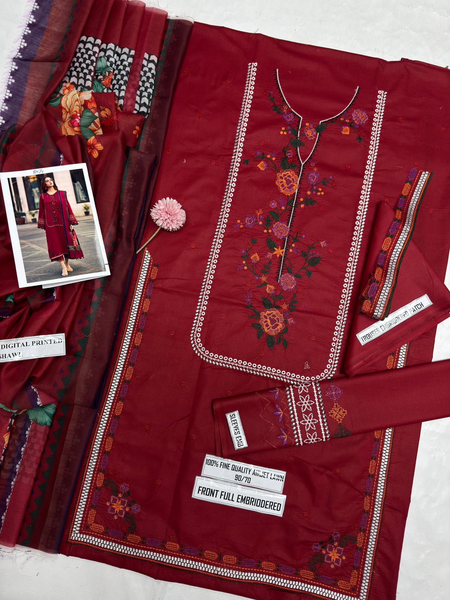 Red embroidered fabric with a person wearing a similar outfit in a smaller inset image.