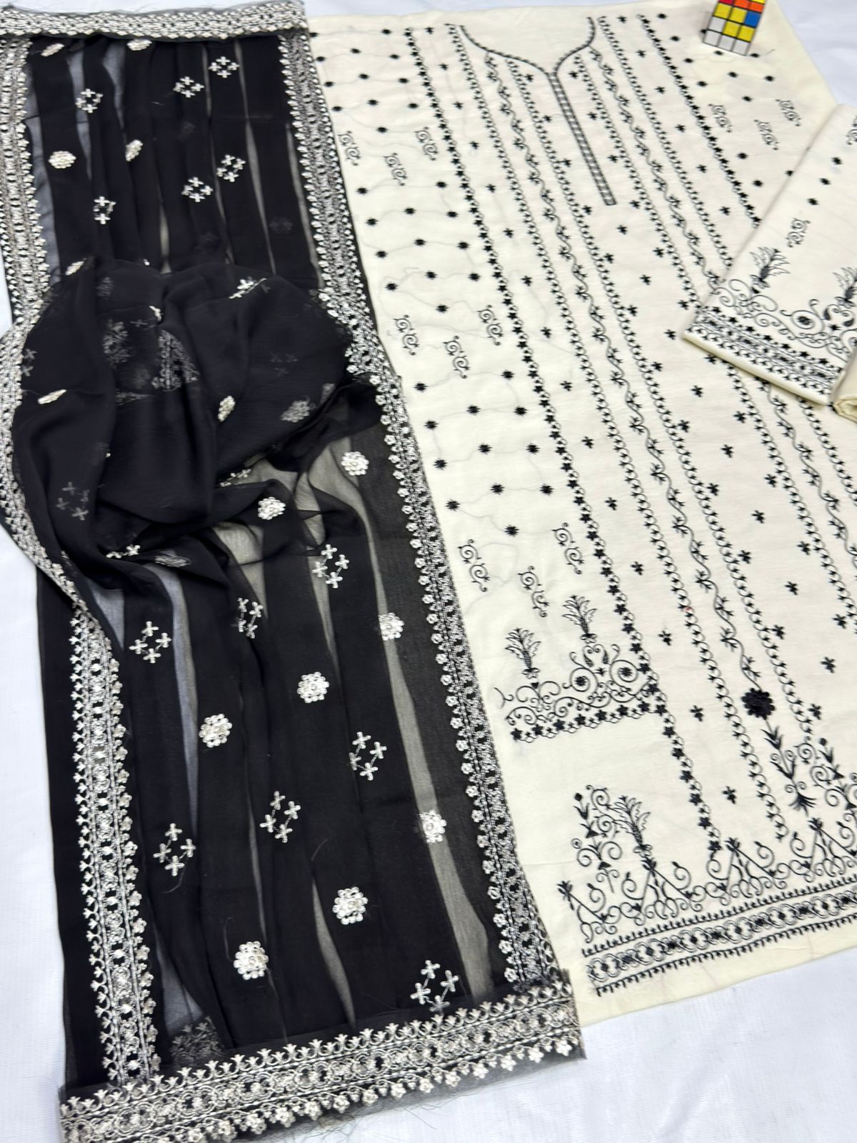 Black fabric with white embroidery on a white background
