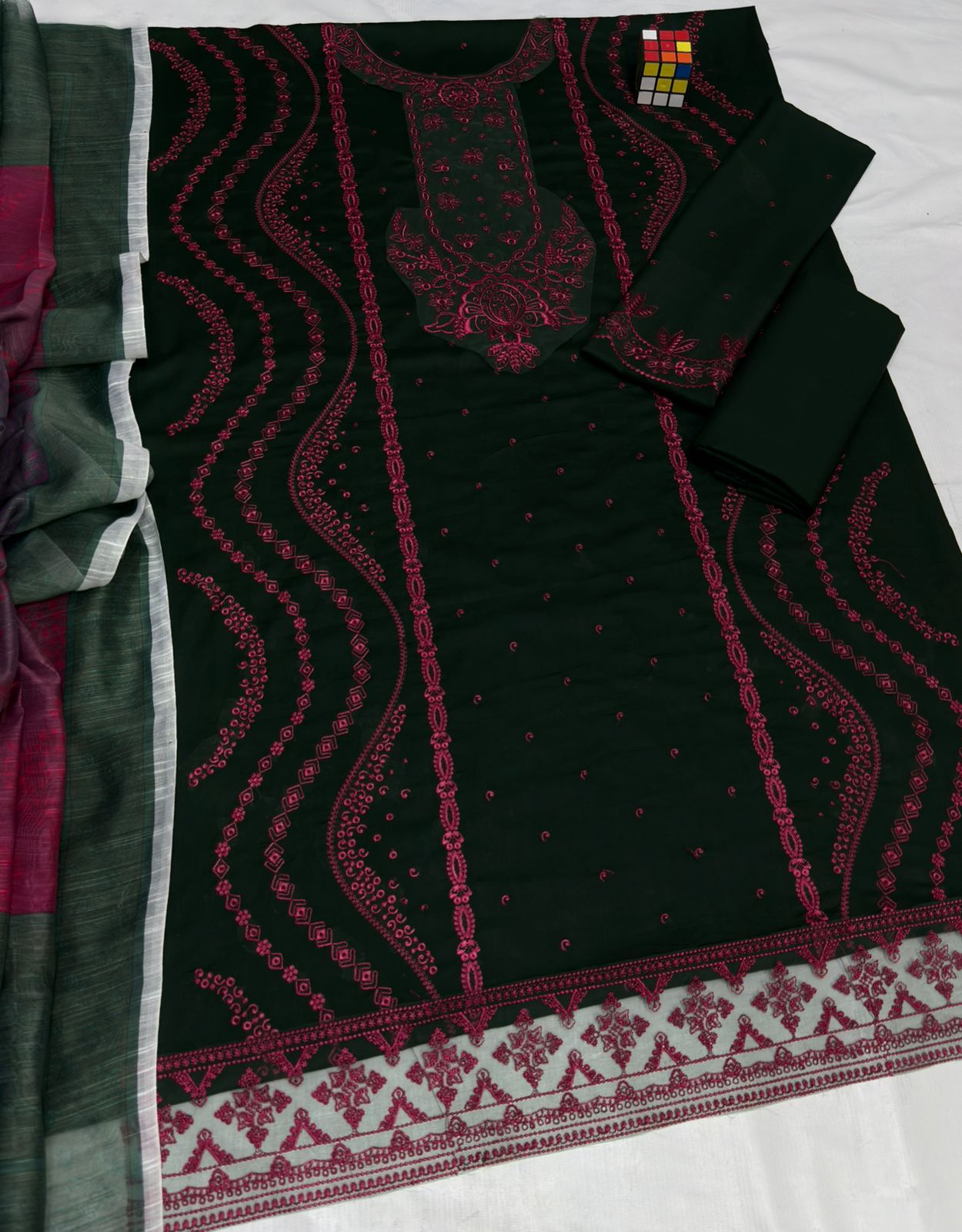 Black embroidered fabric with red patterns on a white background