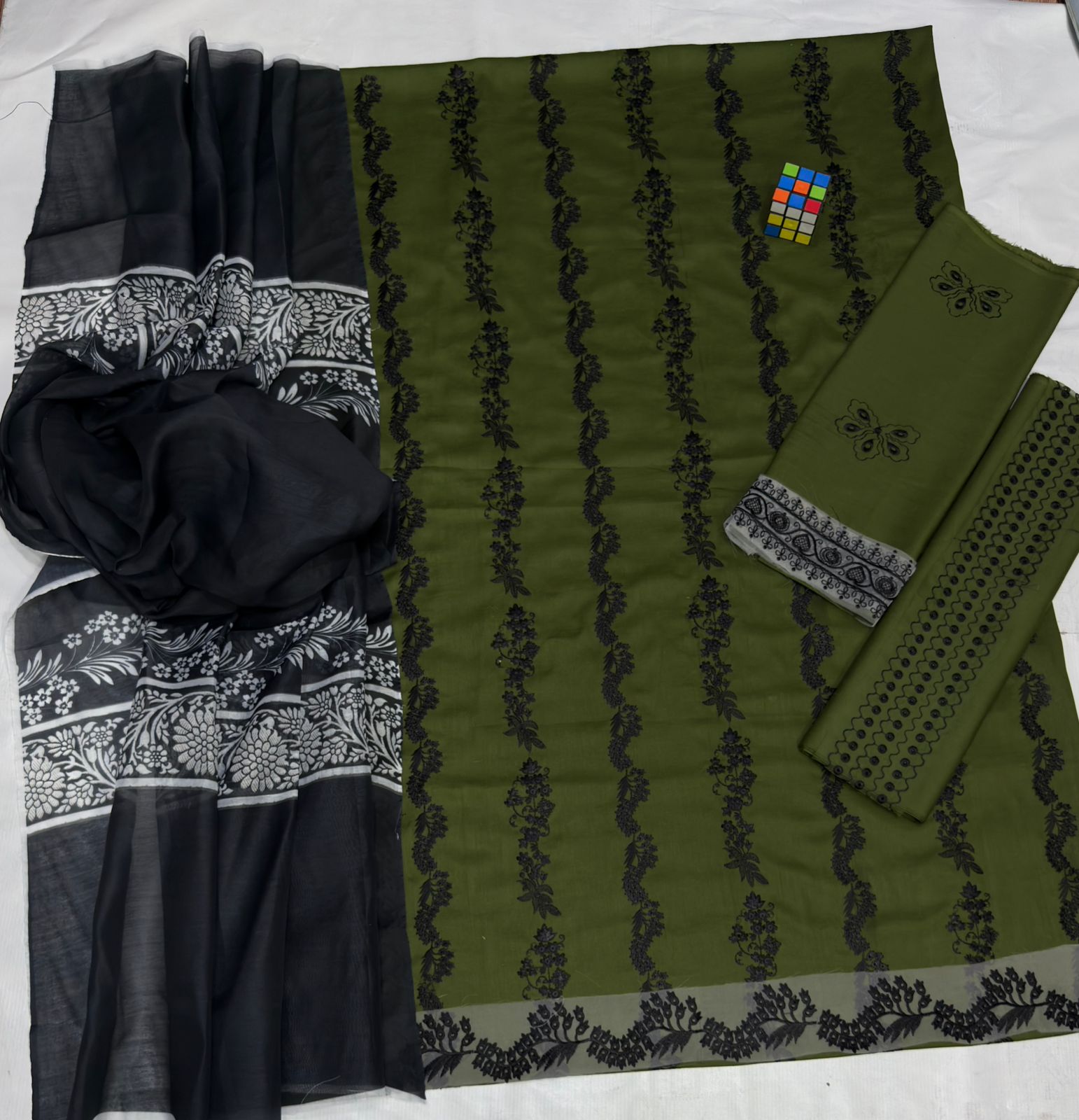 Black and green fabric with intricate patterns on a white background