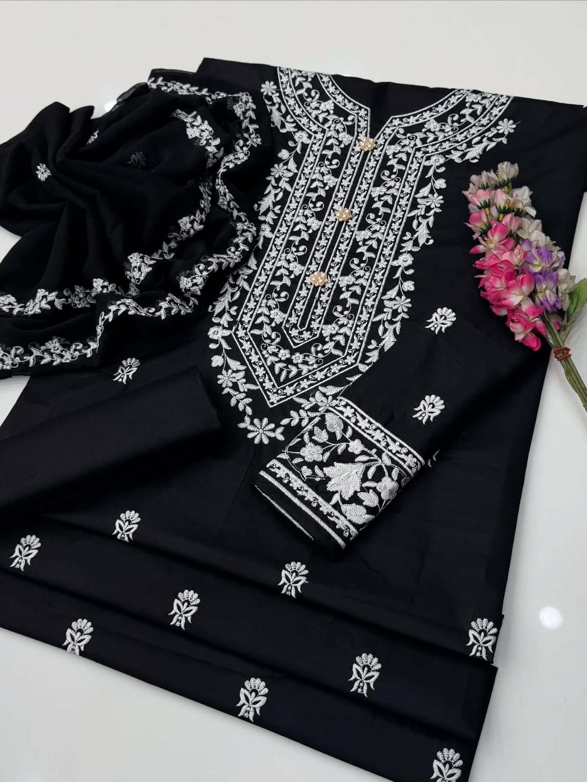 Black fabric with white embroidery on a white background