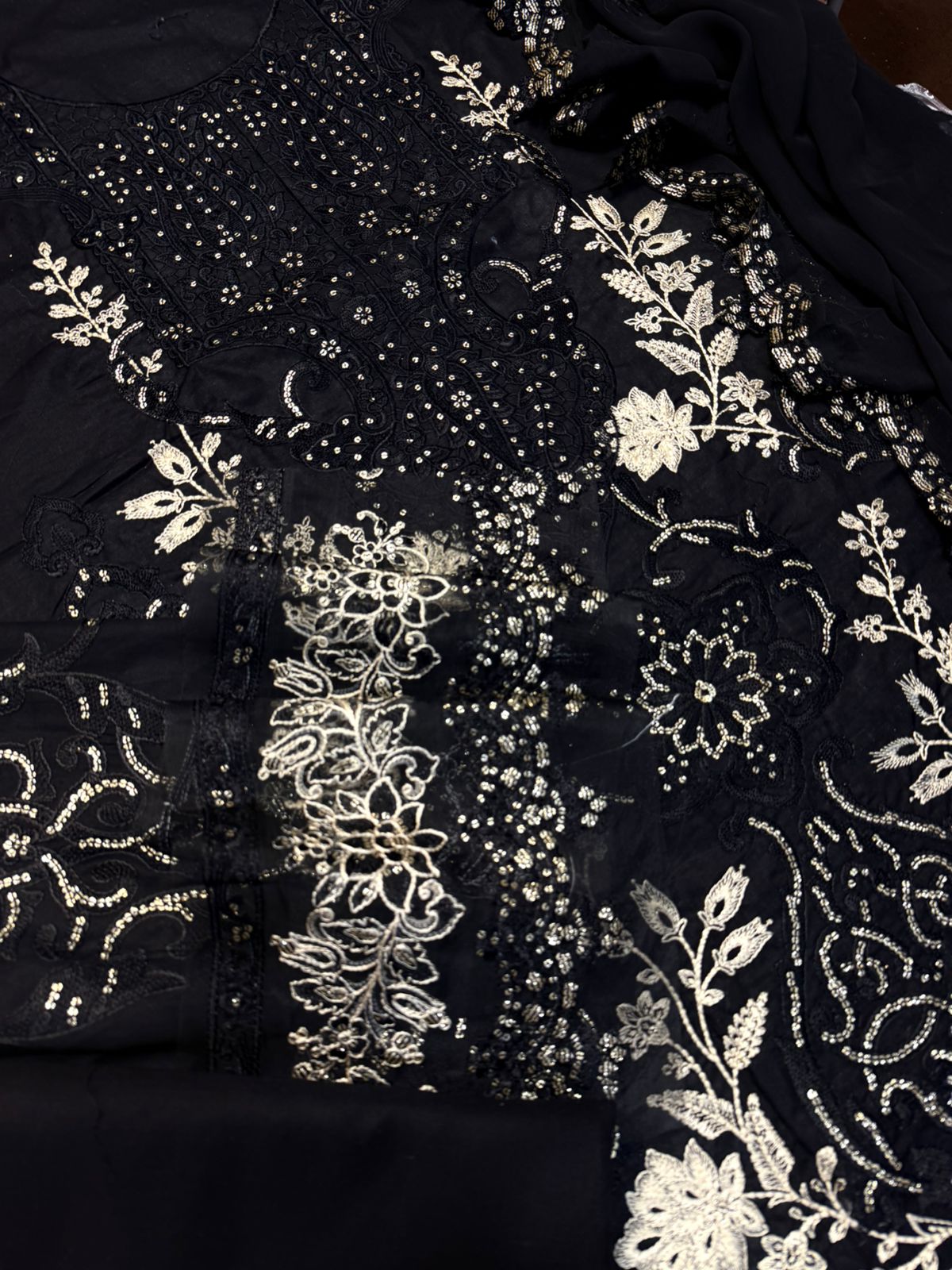 Black fabric with intricate white floral embroidery