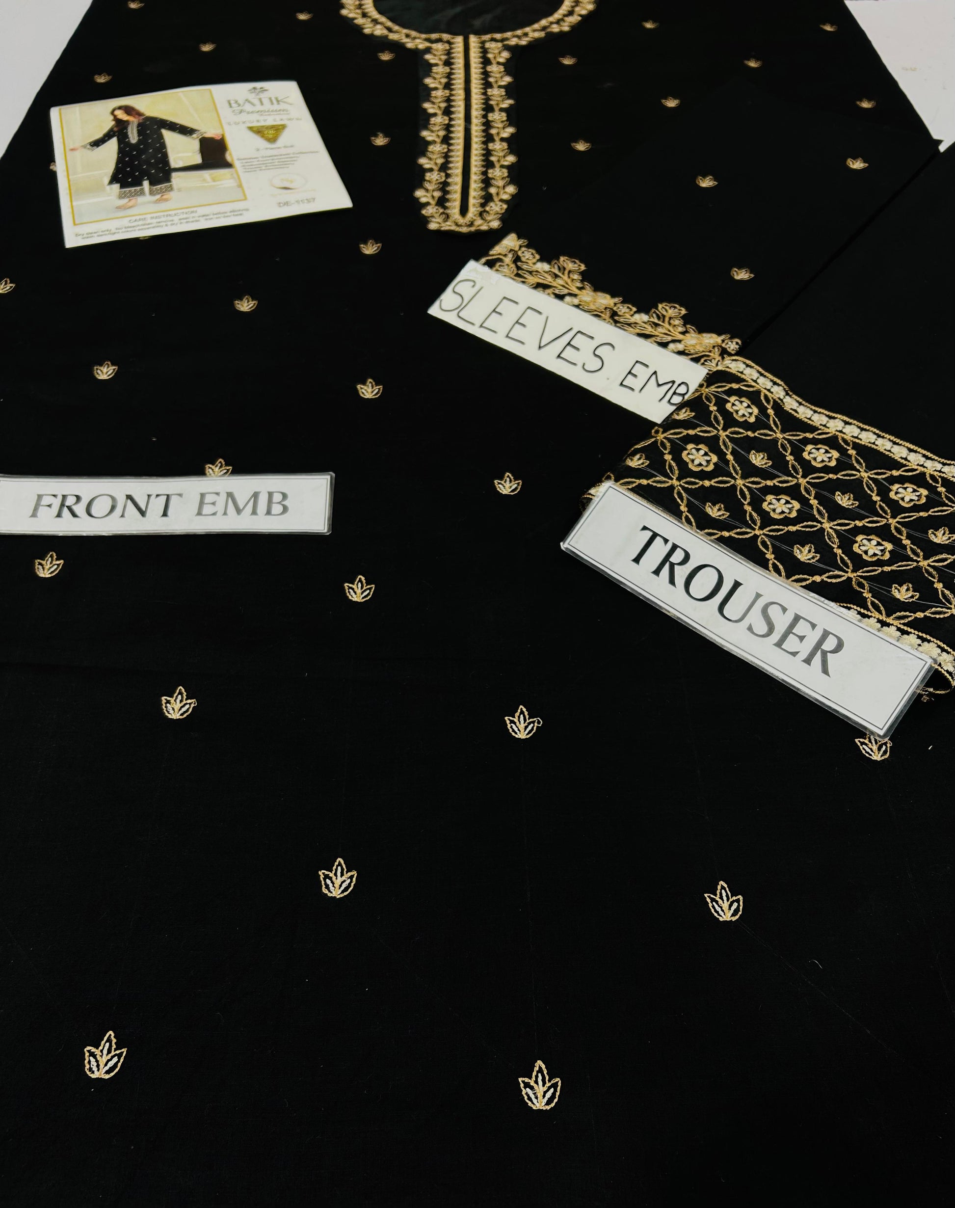 Black fabric with gold embroidery and labeled sections on a black background