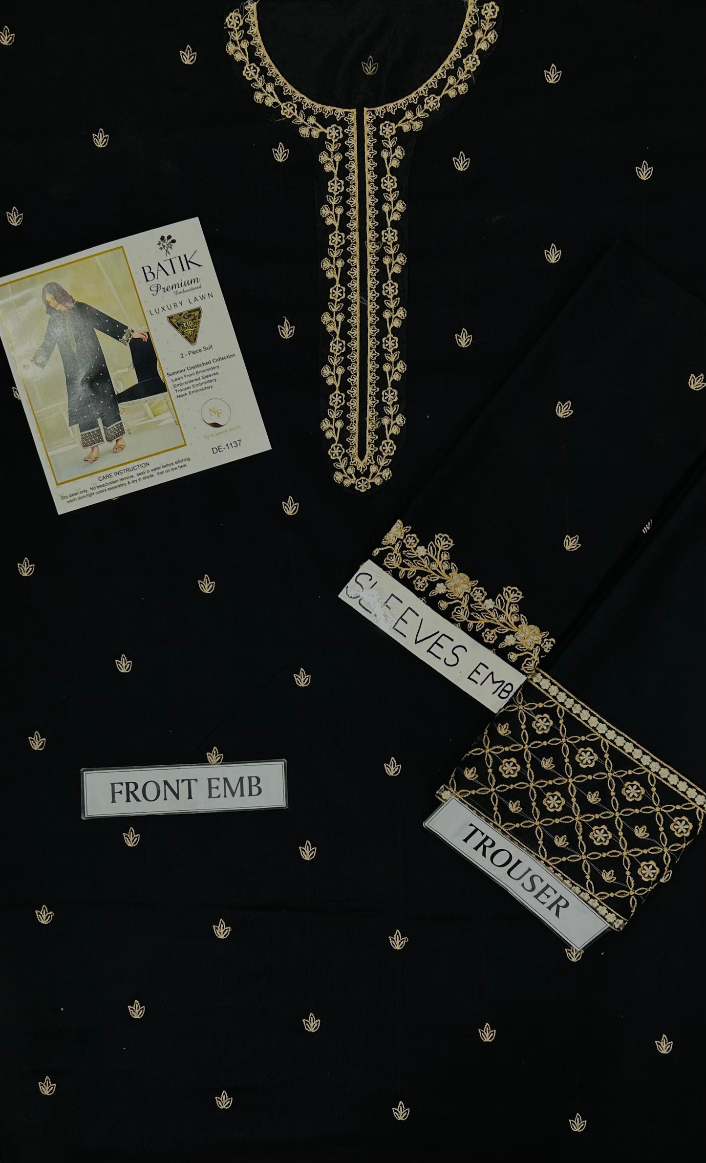 Black fabric with gold embroidery and labels on a black background