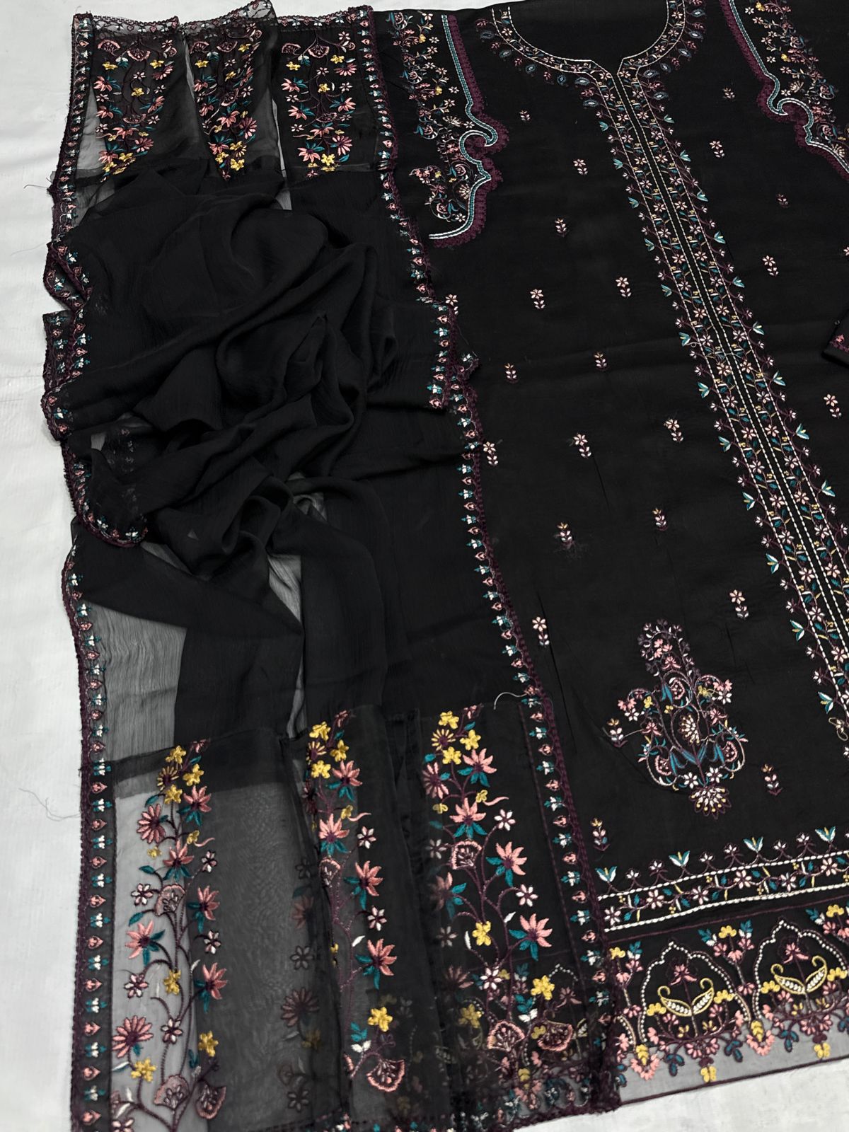 Black embroidered garment on a white background