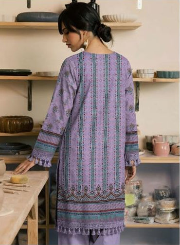 Woman wearing a purple embroidered shirt and pants with a Ripple Collection label.