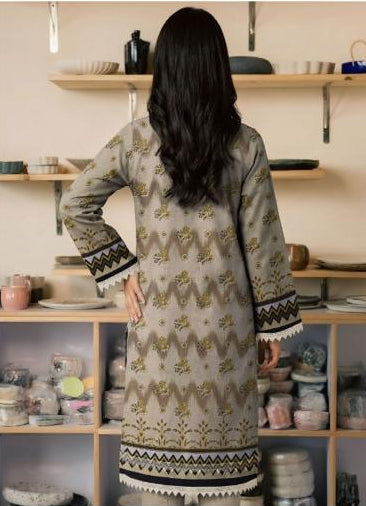Woman wearing a printed shirt and trousers with a Ripple Collection logo.