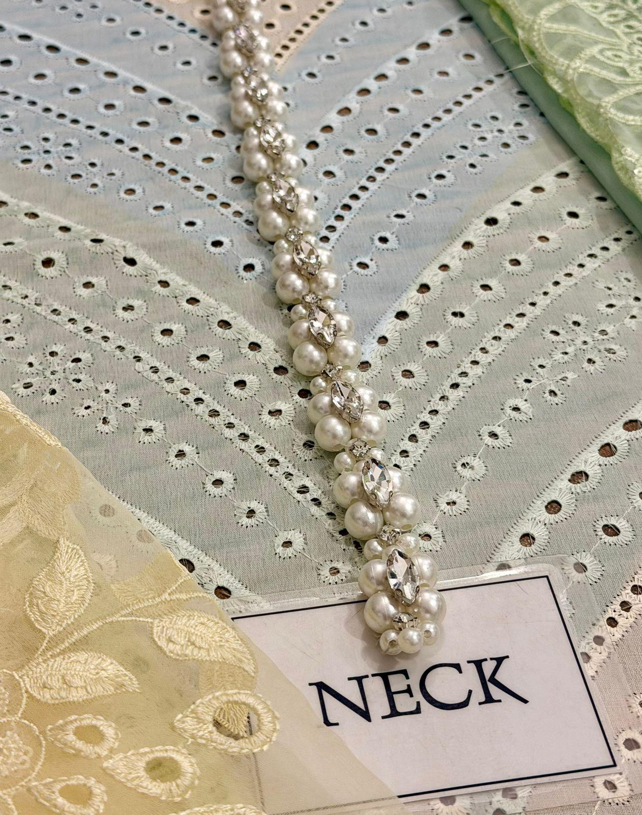 Pearl necklace on a decorative fabric background with a label reading 'NECK'.
