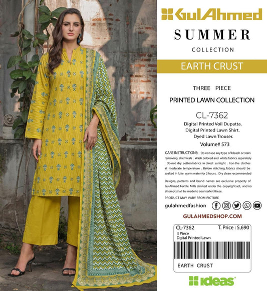 A woman modeling a three-piece printed lawn suit from Gul Ahmed Summer Collection in Yellow Earth Crust. The set includes a yellow kurta with green floral prints, a matching yellow pleated skirt, and a green printed dupatta.