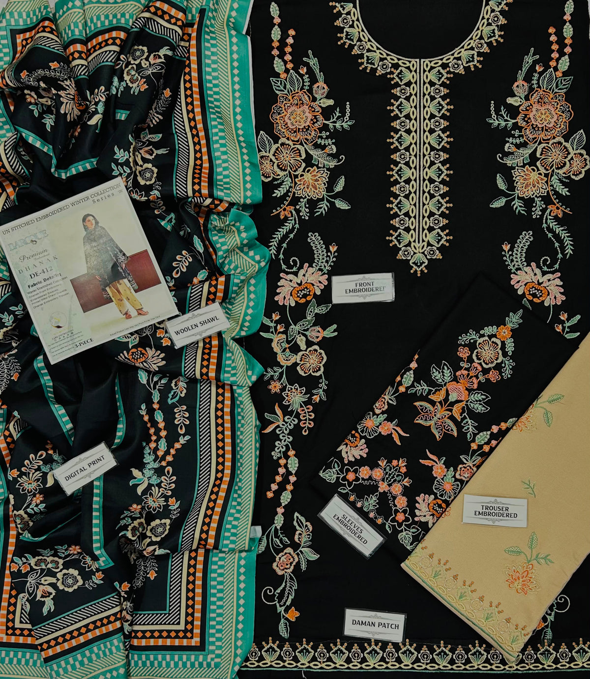 A flat-lay presentation of a women's ethnic wear set, featuring a black kurta with intricate multicolor floral embroidery, a matching printed dupatta, and a beige fabric piece. Several product labels are visible, including 'FASHION LADYWORN' and 'SABIN PULLA'.